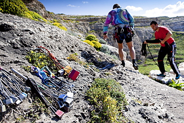 Two men preparing for climbing, climbing equipement in the foreground, Inland Sea, Dwerja Bay, Gozo, Malta, Europe