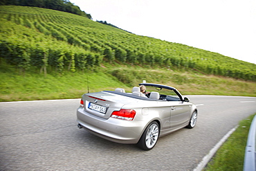 Convertible on road between vineyards near Baden-Baden, Baden-Wuerttemberg, Germany