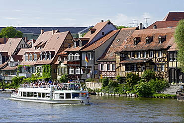 Tourist boat on river Regnitz in the houses of little Venice, Bamberg, Upper Franconia, Bavaria, Germany