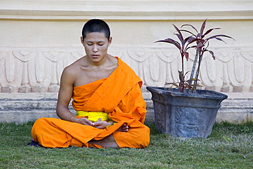 Buddhistic monk sitting in front of monastery Vat Pa Phonphao, Luang Prabang, Laos