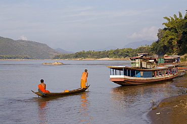 Two young buddhistic monks in a boat on the river Mekong, Luang Prabang, Laos