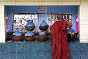 Buddhist monk drinking water at Mahagandhayon monastary in Amarapura near Mandalay, Myanmar, Burma