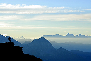 silhouette of hiker in front of Iffinger Spitze and Dolomites with Peitlerkofel, Piz Boe, Langkofel, Fuenffingerspitze and Plattkofel, Spronser Joch, Texelgruppe range, Oetztal range, South Tyrol, Italy