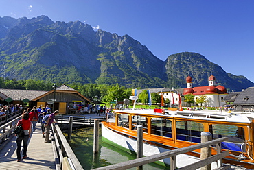 people on landing stage with boat, Watzmann range in background, St. Bartholomae, lake Koenigssee, Berchtesgaden range, National Park Berchtesgaden, Berchtesgaden, Upper Bavaria, Bavaria, Germany