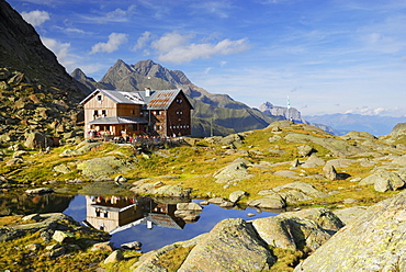 hut Bremer Huette and reflections in little lake, Habicht in background, Stubaier Alpen range, Stubai, Tyrol, Austria