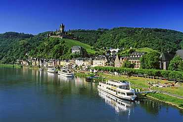 Reichsburg under blue sky and excursion boats at the riverbank, Mosel, Rhineland-Palatinate, Germany