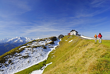 Couple hiking towards hut Statzer Haus on Hundstein, view to Hohe Tauern range, hut Statzerhaus, Dientner Schieferberge range, Dientner Schieferalpen range, Salzburg, Austria