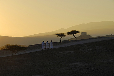 Local men on a path at dawn, Al Hajar mountains, Musandam, Oman, Asia