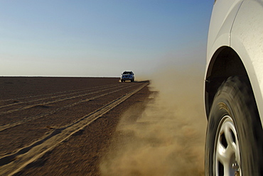 All-terrain vehicles driving on a sandy road under blue sky, Wahiba Sands, Oman, Asia