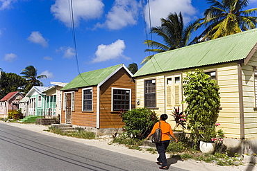 Woman walking along Chattel Houses, Six Men's Bay, Barbados, Caribbean