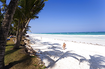 Women walking along Diani Beach, Coast, Kenya