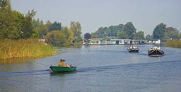 Anglers in a rowing boat and houseboats on the river Vecht, Netherlands, Europe