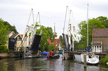 A sailing boat on the river Vecht driving past a bascule bridge, Netherlands, Europe