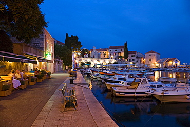 People sitting in front of a tavern at Bol harbour in the evening, Brac Island, Dalmatia, Croatia, Europe