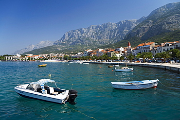 Boats on teh water and houses of Makarska in front of mountain scenery, Dalmatia, Croatia, Europe