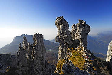 Woman hiking between pinnacles of Grigne, Bergamo Alps, Como, Lombardy, Italy