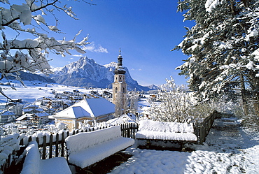 Snow covered houses and church under blue sky, Kastelruth, South Tyrol, Italy, Europe