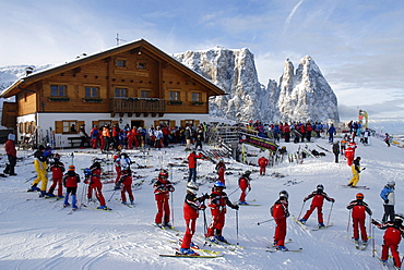 Skiers on a ski slope in front of an inn, Alpe di Siusi, South Tyrol, Italy, Europe