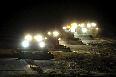 Caterpillars treating the ski slope at night, South Tyrol, Italy, Europe