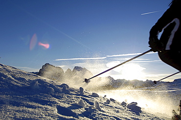 Female Skier skiing down a slope, Mountain landscape, Seiser Alm, Langkofel mountain range, South Tyrol, Italy