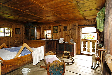 The farmhouse bedroom with bed, cradle and rocking horse, South Tyrolean local history museum at Dietenheim, Puster Valley, South Tyrol, Italy