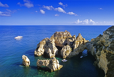 Boats off the rocky coast in the sunlight, Ponta da Piedade, Algarve, Portugal, Europe