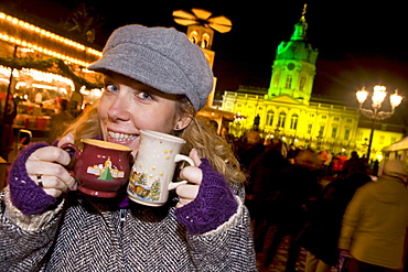 Girl enjoying mulled wine at the Christmas market at Schloss Charlottenburg, Berlin, Germany