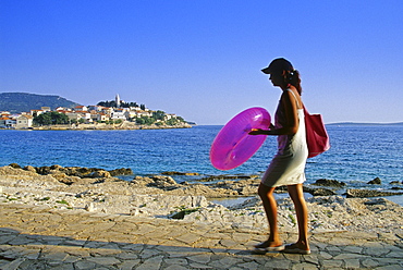 A woman on the seaside promenade of Primosten, Croatian Adriatic Sea, Dalmatia, Croatia, Europe