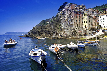 Rubber dingi and fishing boats at harbour under blue sky, Riomaggiore, Cinque Terre, Liguria, Italian Riviera, Italy, Europe