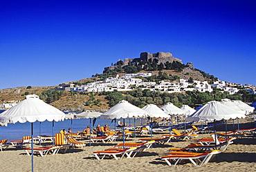 View at bay with beach, city and acropolis under blue sky, Lindos, Island of Rhodes, Greece, Europe