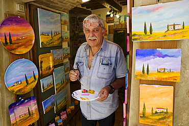 Painter in front of his workshop in Pienza, Tuscany, Italy