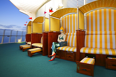 Beach chair with figure aboard AIDA Bella cruiser in the evening