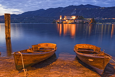 Rowing boats on the lake shore of Lake Orta, Isola San Giulio in the background, Orta San Giulio, Piedmont, Italy