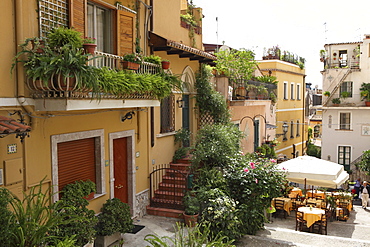 Sunny alley with restaurant in Taormina, Messina Province, Sicily, Italy, Europe