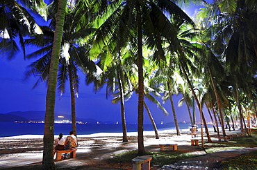 Couple sitting on the beach at night, Nha Trang, Vietnam