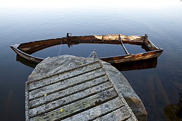 Half sunken wooden rowing boat at a jetty, island of Norrbyskaer, Vaesterbotten, Sweden, Europe