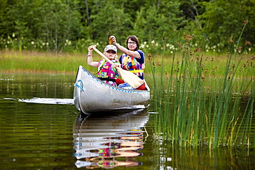A girl and a woman in a canoe on the island of Norrbyskaer, Vaesterbotten, Sweden, Europe
