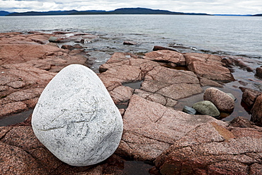 White boulder on red granit rocks at the Hoega Kusten, bay of Storsands Havsbad, Vaesternorrland, Sweden, Europe