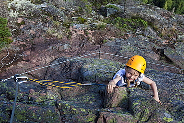 Girl climbing at fixed rope route at Skuleberget, Hoega Kusten, Vaesternorrland, Sweden, Europe