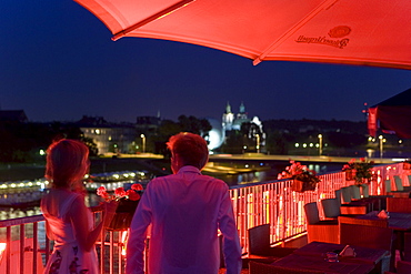 Young couple on the roof terrace of Hotel Poleski at night, Krakow, Poland, Europe