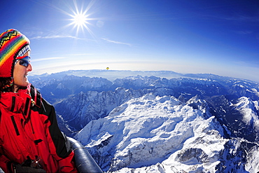 Woman in hot-air balloon enjoying view to Pala range in winter, aerial photo, Pala range, Dolomites, Venetia, Italy, Europe