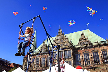 Girl on a swing at childrenÂ¥s party in front of the city hall at the market square, Hanseatic City of Bremen, Germany, Europe