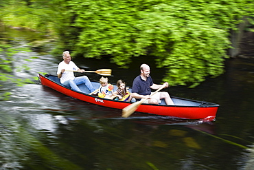 Father, children and grandfather canoeing on the Wuerm River in southern Bavaria, Upper Bavaria, Germany