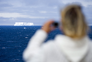 Woman photographing Antarctic iceberg aboard Cruiseship MS Deutschland (Deilmann Cruises), South Shetland Islands, Antarctica