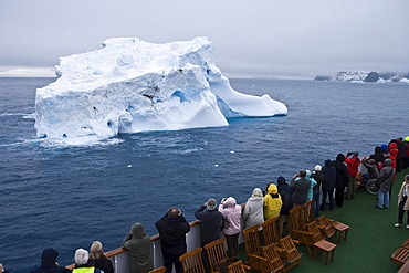 Passengers aboard cruiseship MS Deutschland (Deilmann Cruises) looking at Antarctic icebergs, South Shetland Islands, Antarctica