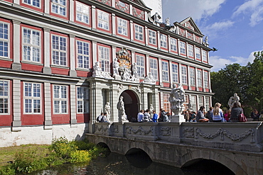 Entrance to Wolfenbuettel castle, now a secondary school, pupils sitting on the bridge, Wolfenbuettel, Lower Saxony, Germany