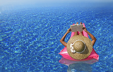 A woman reading a book in an infinity pool, Bohol, Philippines, Asia