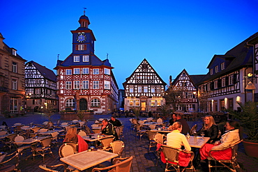 Restaurant guests on the illuminated market square, town hall and market fountain in the background, Heppenheim, Hessische Bergstrasse, Hesse, Germany