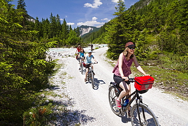 Families cycling along Isar Cycle Route, Hinterau Valley, Karwendel range, Tyrol, Austria