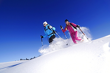 Young women snowshoeing, Hemmersuppenalm, Reit im Winkl, Chiemgau, Upper Bavaria, Bavaria, Germany, Europe